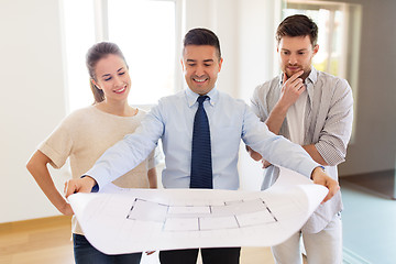 Image showing realtor showing blueprint of new home to couple