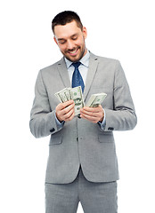 Image showing smiling businessman counting american dollar money