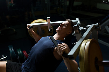 Image showing man doing chest press on exercise machine in gym