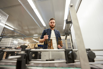 Image showing men with bottles on conveyor at craft beer brewery