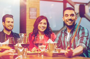 Image showing friends taking selfie by smartphone at restaurant