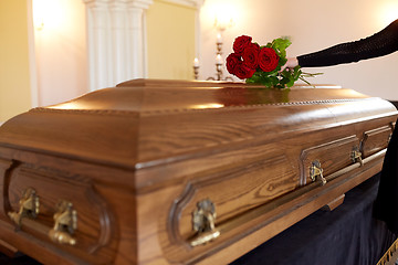 Image showing woman with red roses and coffin at funeral