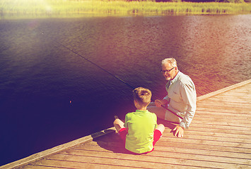 Image showing grandfather and grandson fishing on river berth