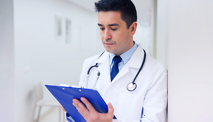 Image showing doctor writing to clipboard at hospital