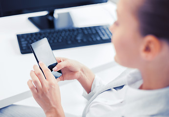 Image showing businesswoman with smartphone in office