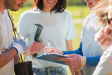 Image showing volunteers with tree seedling and clipboard