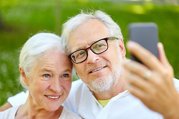 Image showing senior couple with smartphone taking selfie in summer