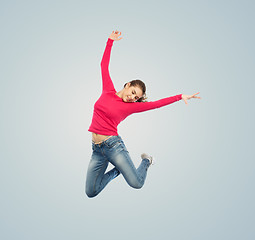 Image showing happy young woman jumping in air or dancing