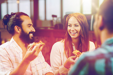 Image showing friends eating pizza with beer at restaurant