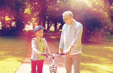 Image showing grandfather and boy with bicycle at summer park