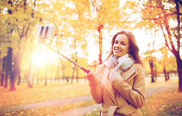 Image showing woman taking selfie by smartphone in autumn park