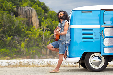 Image showing hippie man playing guitar at minivan car on island