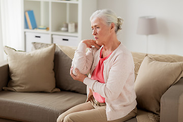 Image showing senior woman suffering from pain in hand at home