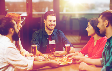 Image showing friends eating pizza with beer at restaurant