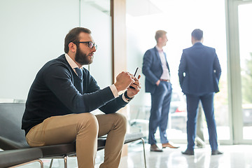 Image showing Businessman using smart phone while sitting in waiting room.