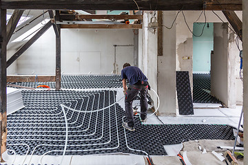 Image showing Pipe fitter mounting underfloor heating.