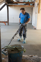 Image showing Laborer polishing sand and cement screed floor.