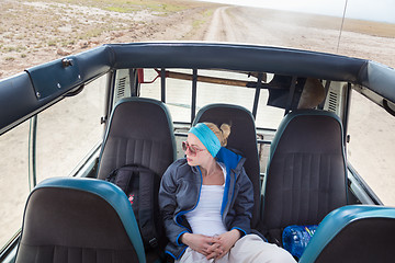 Image showing Woman on african wildlife safari observing nature from open roof safari jeep.