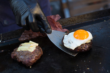 Image showing Chef making beef burgers outdoor on open kitchen international food festival event.