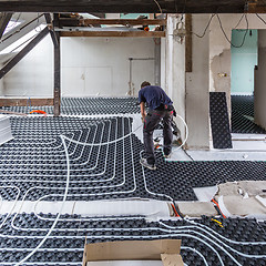 Image showing Pipe fitter mounting underfloor heating.