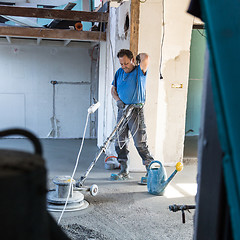 Image showing Laborer polishing sand and cement screed floor.