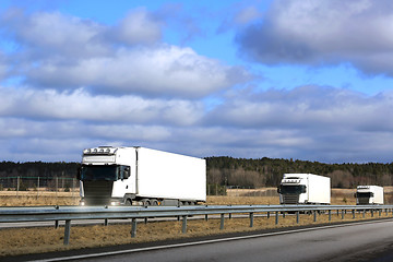 Image showing Three White Semi Trucks Platoon on Freeway