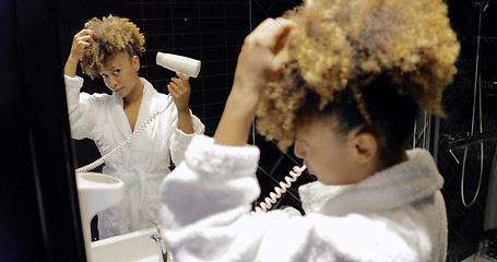 Image showing Charming girl in bathroom using hairdryer