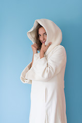 Image showing woman in a white coat with hood isolated on blue background