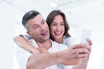 Image showing happy couple using mobile phone at home