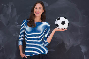 Image showing woman holding a soccer ball in front of chalk drawing board