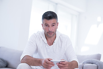 Image showing young man using a mobile phone  at home