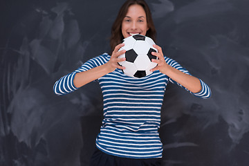 Image showing woman holding a soccer ball in front of chalk drawing board