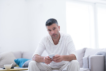 Image showing young man using a mobile phone  at home