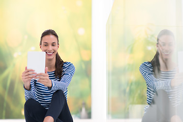 Image showing young women using tablet computer on the floor