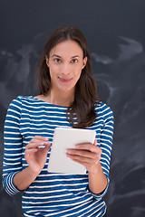 Image showing woman using tablet  in front of chalk drawing board