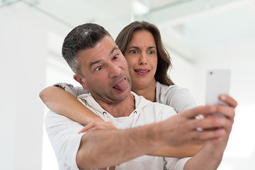 Image showing happy couple using mobile phone at home