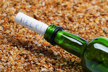 Image showing Bottle of wine with help message on sand in beach at sun summer 