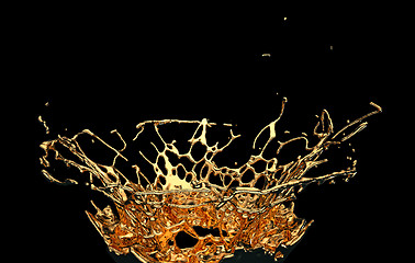 Image showing Melted gold or oil splashes isolated on black