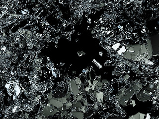 Image showing Pieces of splitted or cracked glass on black