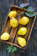 Image showing Ripe pear and autumn leaves in wooden box.