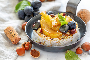 Image showing Grilled camembert with pears and black grapes.