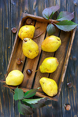 Image showing Yellow pears and chestnuts in an old box.
