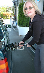 Image showing Female pumping petrol.