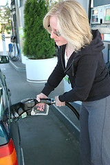 Image showing Female pumping petrol.