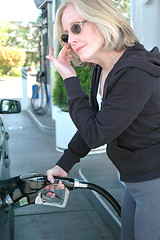 Image showing Female pumping petrol.