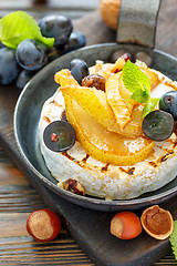 Image showing Camembert baked with pear and black grapes. 