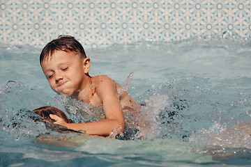 Image showing Two happy children playing on the swimming pool at the day time.