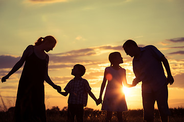 Image showing Happy family standing in the park at the sunset time.