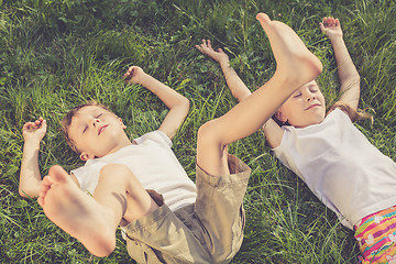 Image showing Two happy children playing on the grass at the day time.