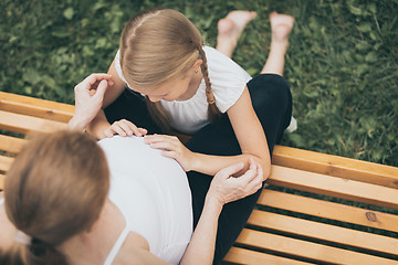 Image showing Happy little girl  hugging mother in the park at the day time.